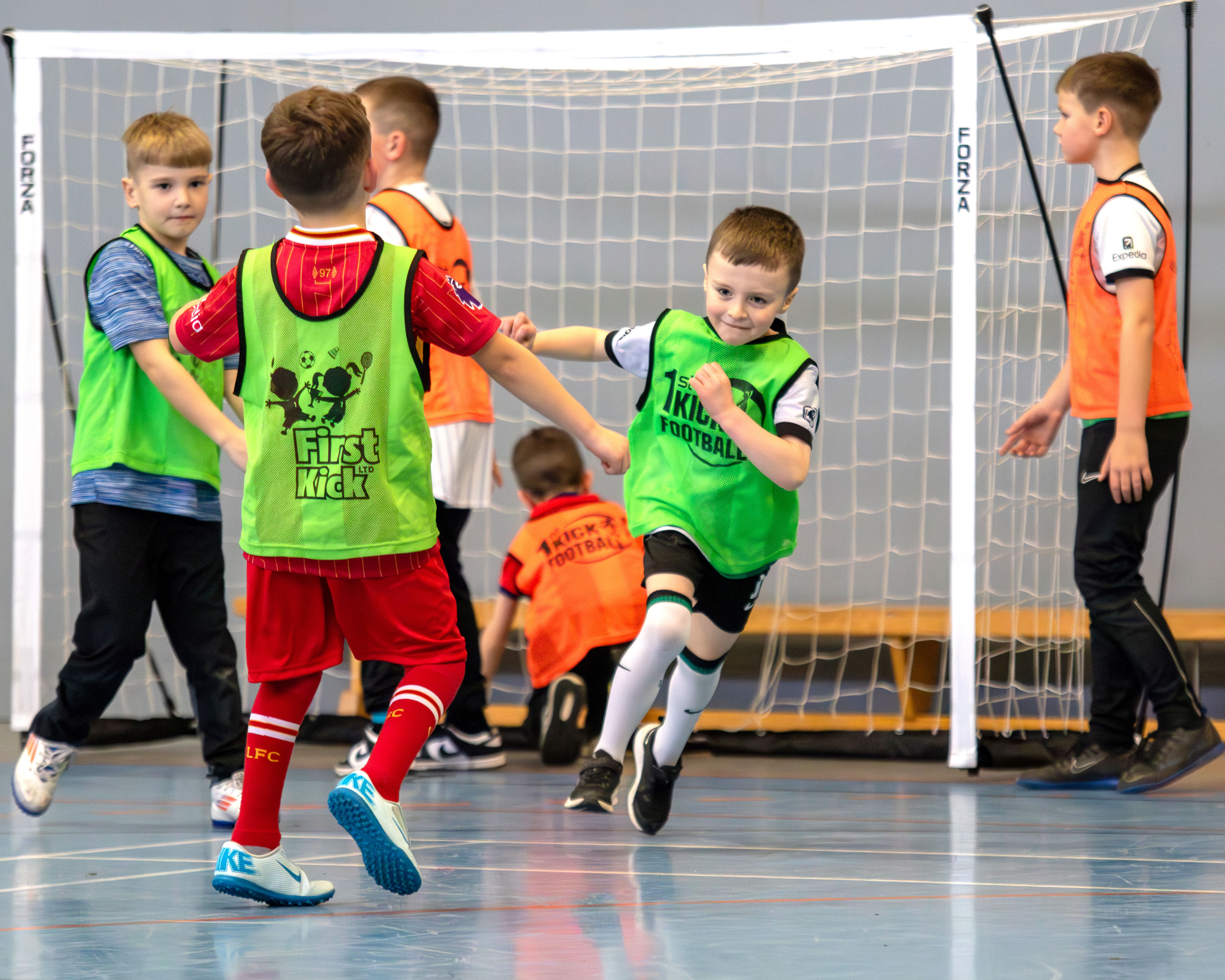 Children in First Kick bibs celebrating a goal